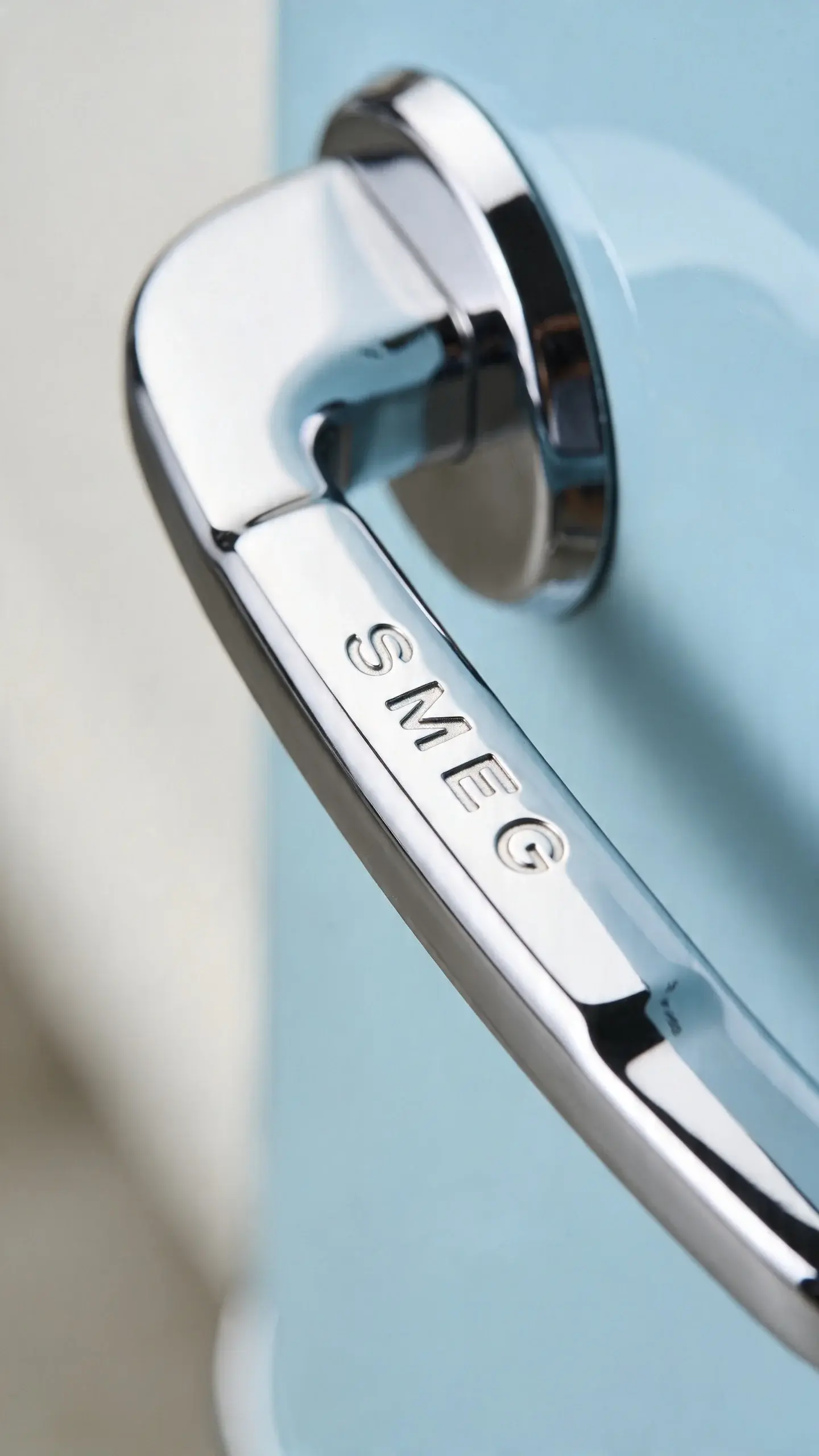 polished chrome handle of Smeg HMF01BLEU, tight macro